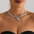 Silver-tone chain necklace with large heart and small hanging charms, worn