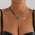 Asymmetric dark bead necklace with heart and gold-tone crescent drop, modeled