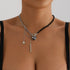 Asymmetric black and silver-tone beaded necklace with large dark heart, worn
