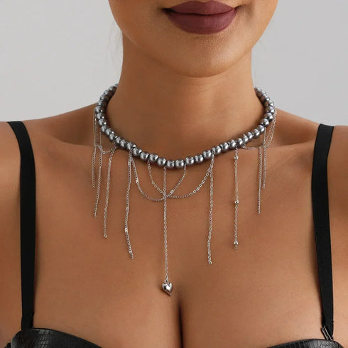 Layered silver-tone beads with a long small-heart drop, modeled close-up