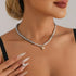 Small pointed heart necklace styled above a black neckline