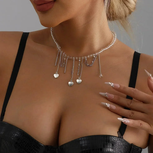 Fine pale bead necklace with multiple dangling silver-tone heart charms, side neckline view