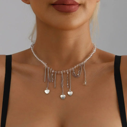 Multiple small heart drops suspended from a pale necklace, centered model view