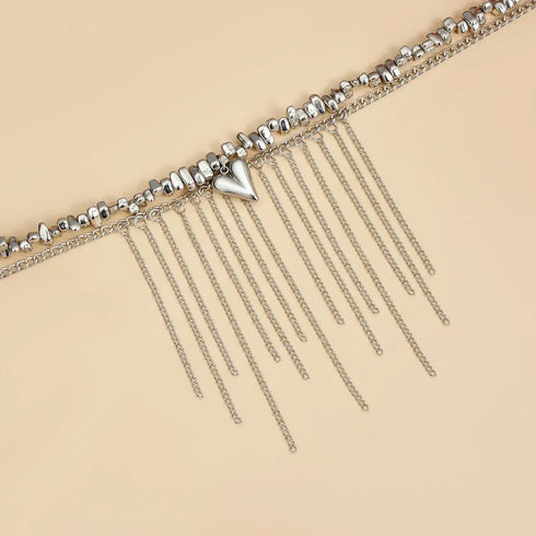 Close-up of bead strand and long hanging chain fringe on beige
