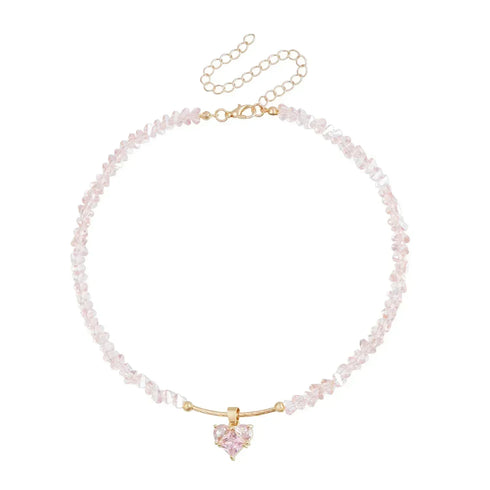 Pale pink irregular beads with matching heart pendant, laid flat on white