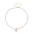 Pale pink irregular beads with matching heart pendant, laid flat on white