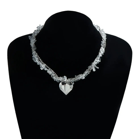 Irregular pale bead strand and large heart pendant displayed on a black bust