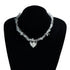 Irregular pale bead strand and large heart pendant displayed on a black bust