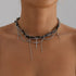 Dark beaded layers with long cross charm and draped chains, modeled