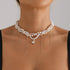 White layered necklace with gold-tone drops and small center heart, worn