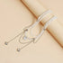 Layered pale beads and silver-tone chain necklace arranged on beige fabric