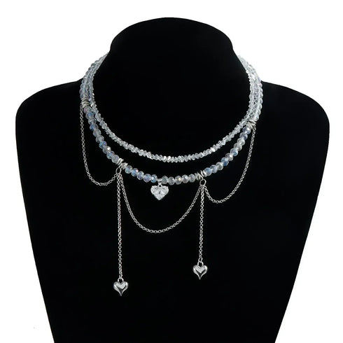 Pale layered beaded heart necklace displayed on a black bust