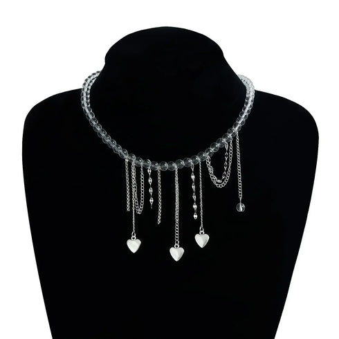Pale beaded heart-drop necklace displayed against a black bust