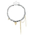 Mixed-tone bead and pointed heart necklace laid flat with extension chain visible