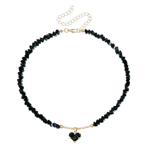 Black irregular bead necklace with black heart pendant, laid flat on white