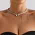 Silver-tone heart necklace with an asymmetric long chain drop, worn with a black top