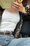 Brown cork belt with an oval silver-tone buckle worn with blue jeans