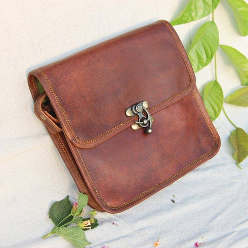 Angled view of brown leather bag showing stitched edges and flap