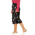 Front close view of black polka-dot pleated skirt and midi hem