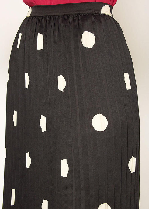 Close-up of elastic waistband and pleats on black polka-dot skirt