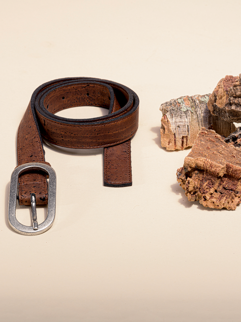 Rolled brown cork belt beside cork bark, showing its single-prong buckle
