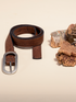 Rolled brown cork belt beside cork bark, showing its single-prong buckle