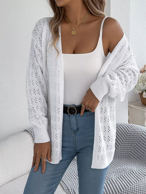 White crochet-knit cardigan, draped off one shoulder to show sleeve texture