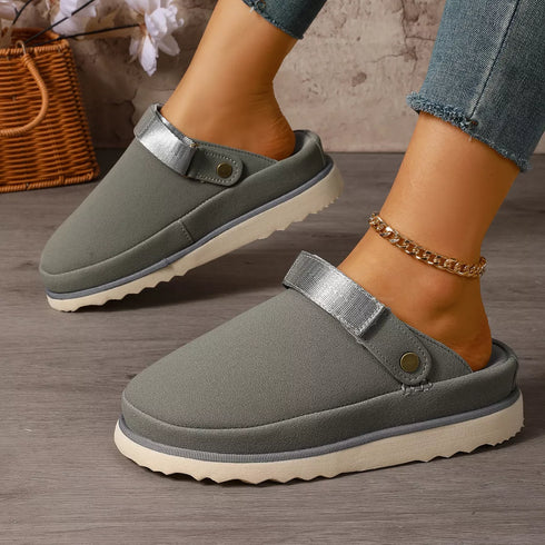 Gray clogs worn on a model showing closed toes and open backs