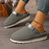 Gray clogs worn on a model showing closed toes and open backs