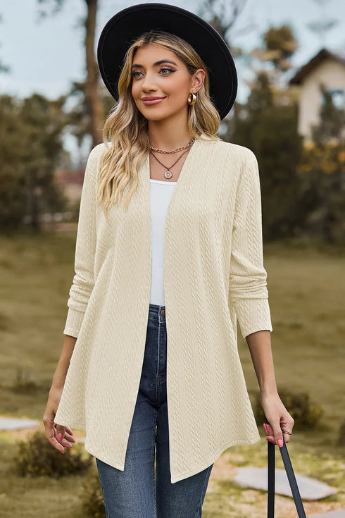 Cream textured long cardigan worn open with a hat