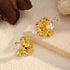 Angled view of gold-tone flower earrings with faceted accents