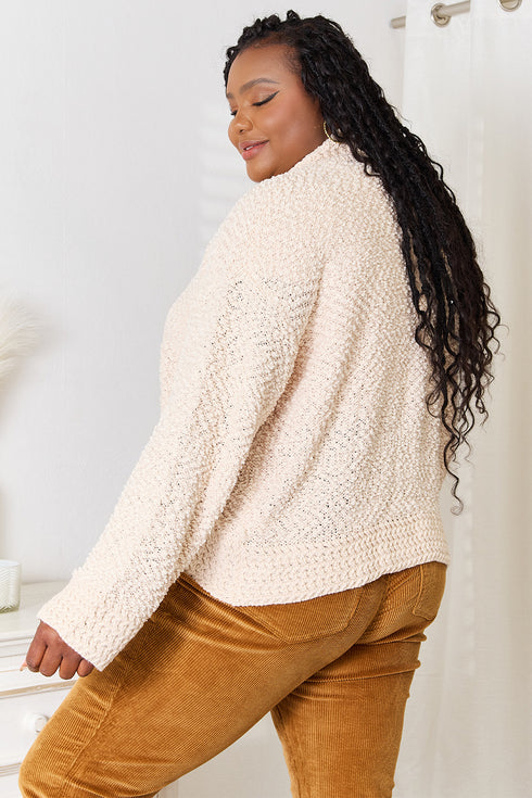 Rear angled view of cream knit cardigan on a second model