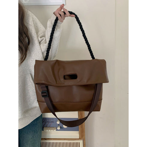 Brown hobo bag showing cutout handle and long adjustable strap