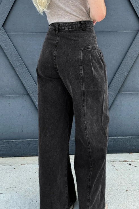Back view of black wide-leg jeans showing patch pockets and belt loops