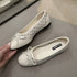 Close-up of beige ballet flats showing bow and perforated upper