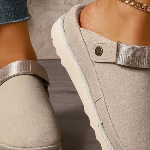 Close-up of beige clog showing its strap pivot and side profile