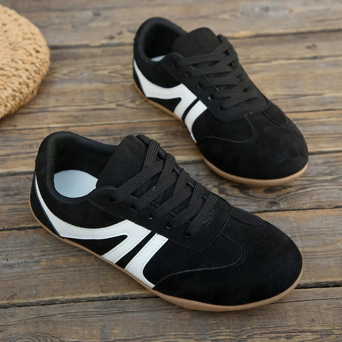 Black lace-up sneakers displayed on wooden steps