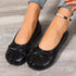 Black split-toe ballet flats worn on a model, front view