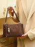 Brown Buckle-Detail Crossbody Bag: Brown bag held by short strap, front view