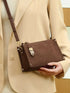Brown Buckle-Detail Crossbody Bag: Brown crossbody bag worn with beige coat, front view