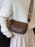 Coffee brown crossbody bag shown at an angle near the hip