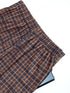 Close-up of brown plaid pants showing ruched waistband fabric