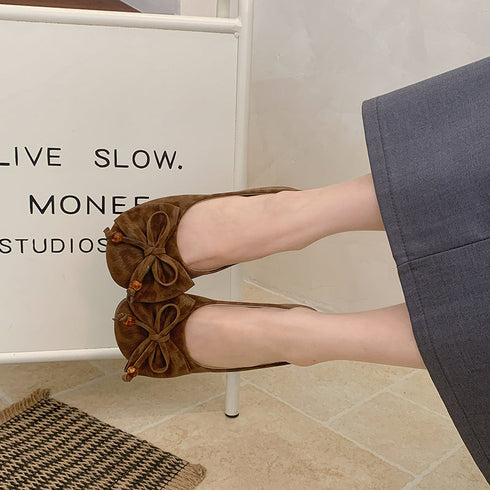 Top view of brown ballet flats with large front bows