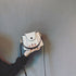White mini bucket bag with black edging and curved front flap