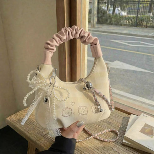 Cream mini purse with pink handle displayed beside a chair