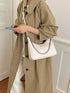 Chain-Detail Shoulder Bag: White chain-detail bag worn, angled front view