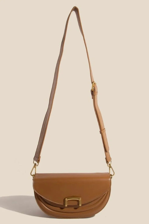 Camel crescent purse hanging from its adjustable shoulder strap