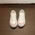 Top view of white lace-up platform sneakers with closed round toes
