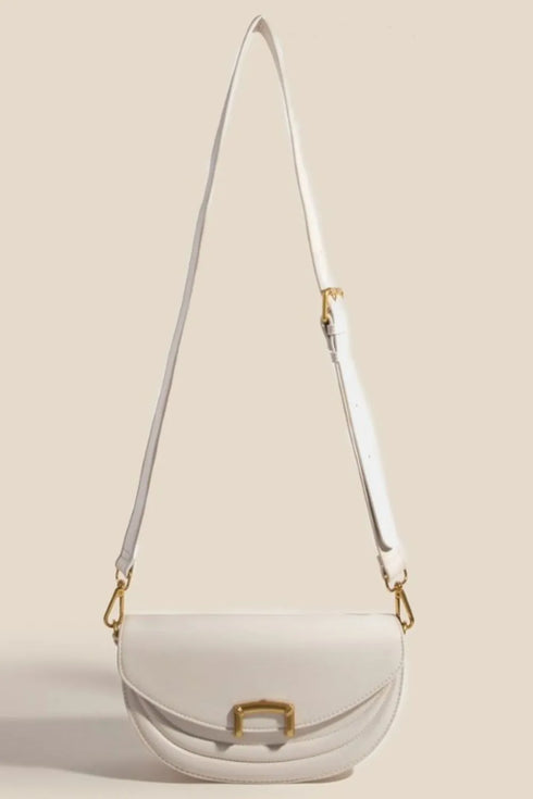 Beige crescent purse shown with its full crossbody strap