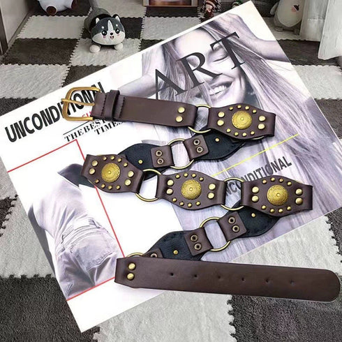Brown medallion belt arranged on a magazine, showing round metal accents and pin buckle